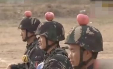 Trajnimet ekstreme të ushtrisë kineze: Ushtari qëndron i ulur dhe mbi kokë mban një mollë, derisa kolegu i tij qëllon me revole (Video)