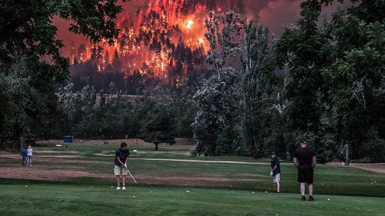 Pasaniku injorant vazhdonte të luaj golf, pranë malit të përfshirë nga zjarri (Foto)
