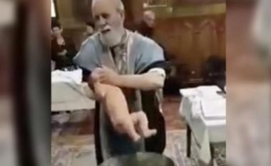Priftin e nervozon foshnja që vazhdimisht qante gjatë pagëzimit, humb durimin dhe ia vë gojën në dorë për ta ndalur (Video)