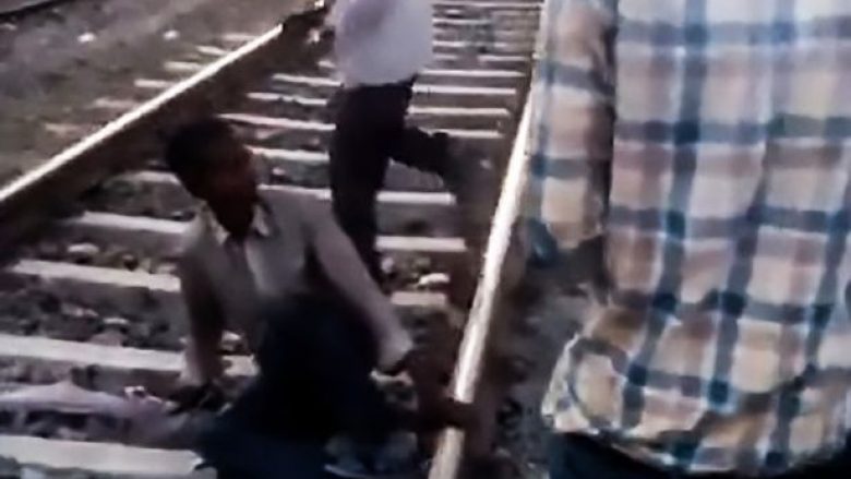 Qëndron i shtrirë në binarë, treni me dhjetëra vagonë kalojnë mbi të – burri shpëton pa asnjë lëndim (Video)