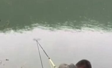 Derisa po tymoste duhan, peshku nisi t’ia tërhiqte shkopin dhe u detyrua të hidhej në liqe (Video)