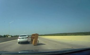 I shfaqet nga askund në mes të autostradës, shoferi i veturës përplaset me dollapin e librave (Video)