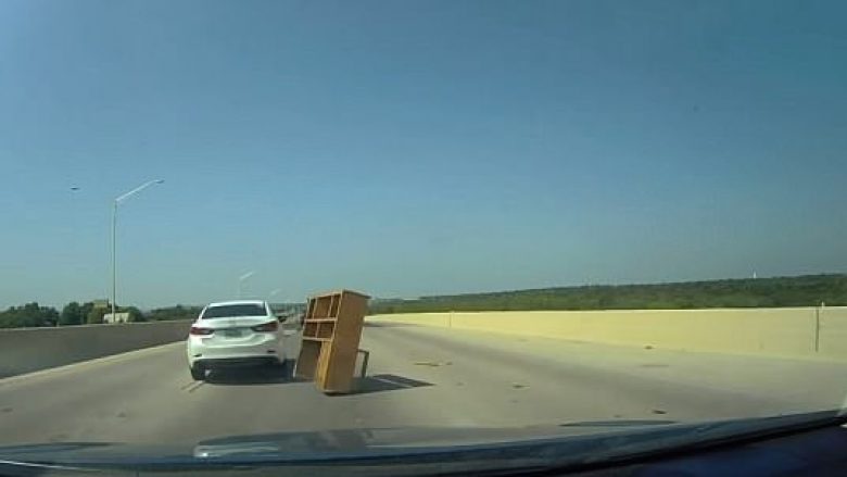 I shfaqet nga askund në mes të autostradës, shoferi i veturës përplaset me dollapin e librave (Video)