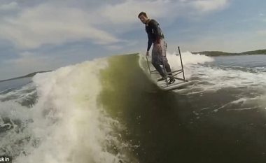 Surfoi nëpër sipërfaqen e liqenit, duke qëndruar sipër një tavoline të kthyer së prapthi (Video)