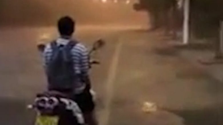 Në vendin ku qëndron motoçiklisti asfalti ishte i thatë, kurse pak metra larg tij binte shi i rrëmbyeshëm (Video)