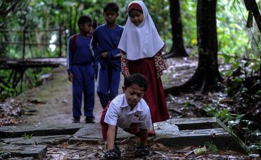 Nxënësi indonezian ndihmohet me duar për të ecur mbi tri kilometra që të shkojë në shkollë, shkaku i gjendjes së këmbëve (Video)