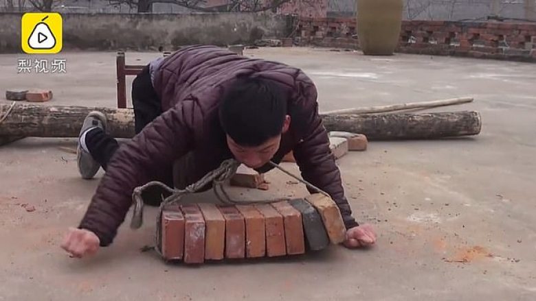 Kinezi me paralizë cerebrale ngre tulla me dhëmbë, për të fituar para për ta ndihmuar familjen (Video)