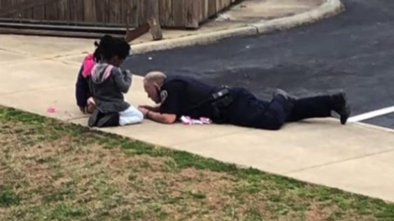 Polici amerikan që po habit botën, për t’i qetësuar fëmijët e frikësuar u shtri në tokë për të luajtur me ata (Video)
