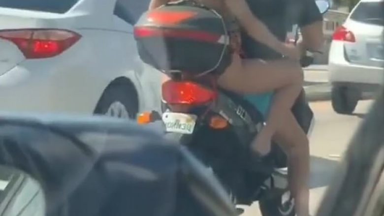 Rruante këmbët në mesin e autostradës, derisa ishte në pjesën e pasme të motoçikletës (Video)