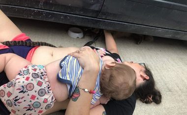 Nëna ushqeu të birin me gji edhe pse ishte e shtrirë, duke e nxjerrë qenin e ngecur nën veturë (Foto)