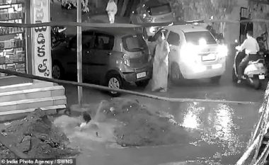 Nëna me fëmijë në krah ra një gropë me ujë të papastër të hapur në mes të rrugës