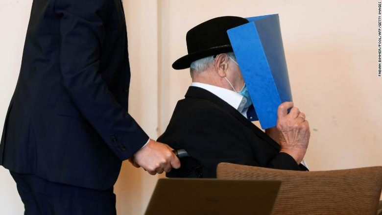 Bruno Dey, a former SS-watchman at the Stutthof concentration camp, hides his face behind a folder as he arrives on a wheelchair for a hearing in his trial on July 23, 2020 in Hamburg, northern Germany. - The 93-year-old former Nazi concentration camp guard was handed a suspended sentence of two years in prison as a court in Hamburg found him guilty of complicity in WWII atrocities. In what could be one of the last such cases of surviving Nazi guards, Bruno Dey was convicted for his role in the killing of 5,230 people when he was a teenaged SS tower guard at the Stutthof camp near what was then Danzig, now Gdansk, in Poland. (Photo by FABIAN BIMMER / POOL / AFP) (Photo by FABIAN BIMMER/POOL/AFP via Getty Images)