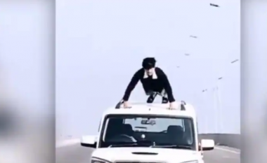 Djali hipën mbi veturën në lëvizje dhe fillon të bëjë ushtrime në një video virale, gjobitet nga policia indiane