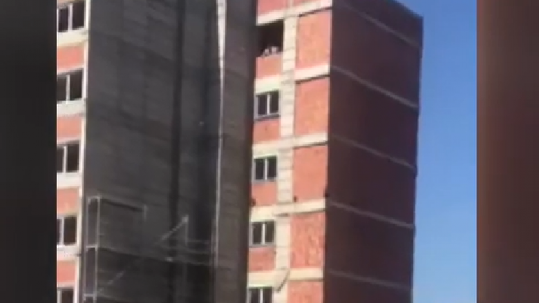 Punëtorët hedhin materiale ndërtimore nga kati i 12-të afër një çerdheje në Prishtinë