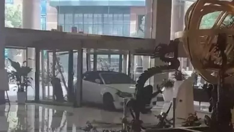 Vizitori i nervozuar futet me veturën e tij përmes hollit të një hoteli në Shangai – pas një debati rreth një laptopi të humbur