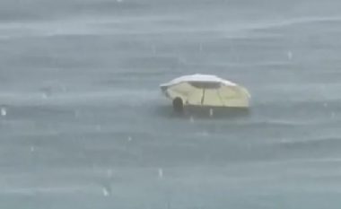 Pavarësisht se binte shi, pushuesi në Ulqin nuk ndalet – futet me ombrellë në ujë