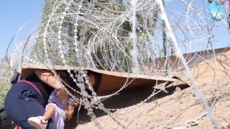 E dhimbshme: Një nënë dhe fëmija e saj duke qarë ndërsa kalojnë nën tela me gjemba – duke tentuar të kalojnë kufirin ndërmjet Meksikës dhe SHBA-së